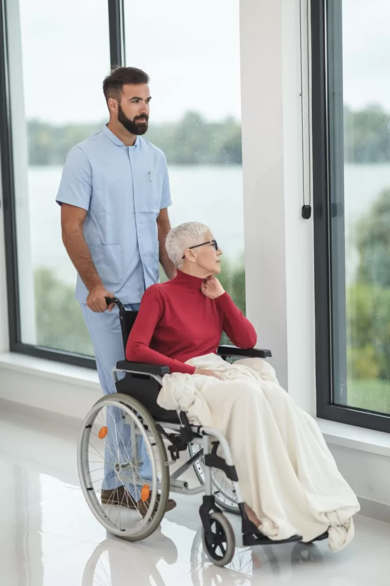 support worker pushing an elderly woman on wheelchair