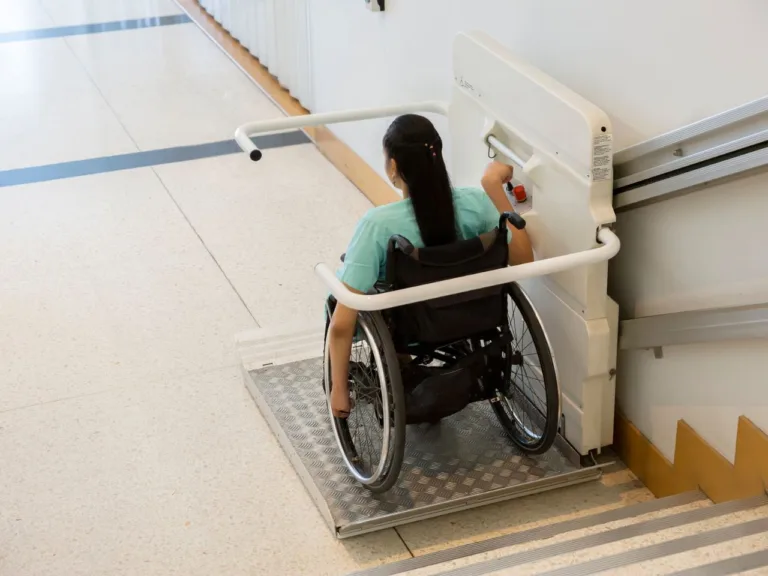 woman on a wheel chair at the base of a staircase