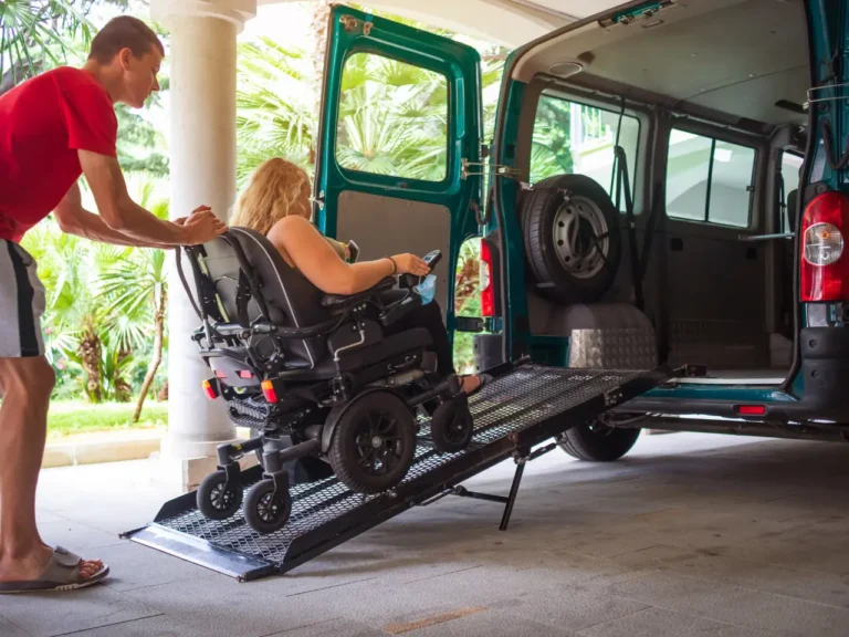 a man helping a woman on a wheelchair into the bus