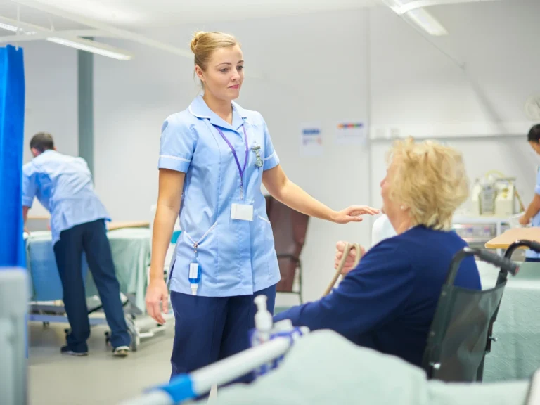 A female nurse talking to a woman sitted on wheelchair