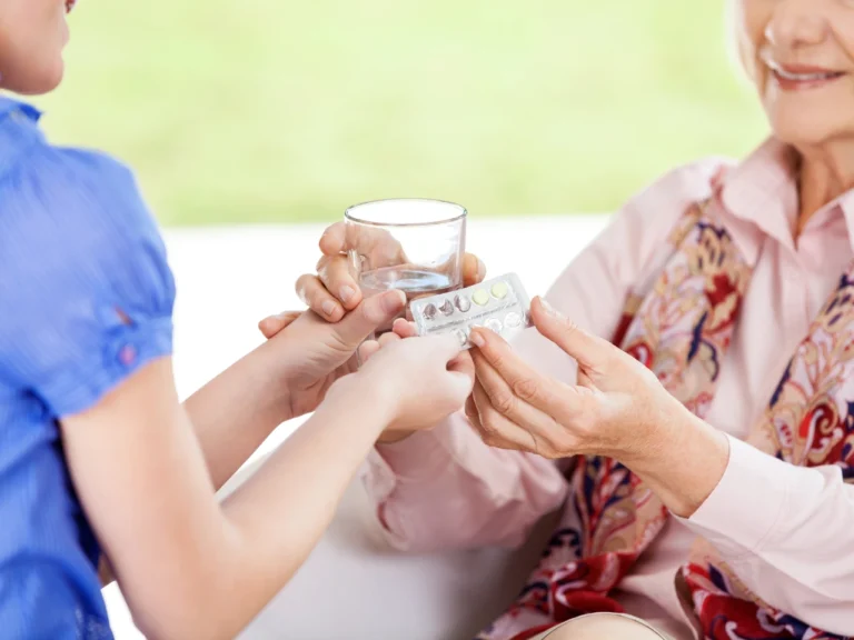 a lady administering medication to an elderly woman